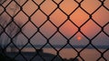 Sunset captured through the fence Royalty Free Stock Photo