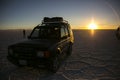 Sunset and car in Uyuni salar in Cordillera Real, Andes, Bolivia Royalty Free Stock Photo