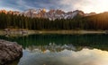 Sunset at Carezza lake with beautiful reflections of dolomites mountains Royalty Free Stock Photo