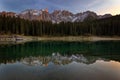 Sunset at Carezza lake with beautiful reflections of dolomites mountains Royalty Free Stock Photo