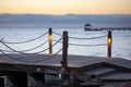 Sunset on the Caribbean coast.Wooden poles and rope railings of the pier Royalty Free Stock Photo