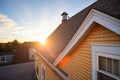 sunset casting shadows on a shingle gambrel roof