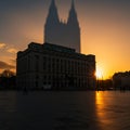 A sunset casts a dramatic shadow of a tall, twin-spired structure onto a rectangular Royalty Free Stock Photo