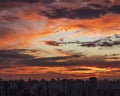 Sunset in city with industrial skyline and clouds.