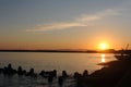 Sunset with a clear sky and sunlight reflexing on the surface of an ocean in the evening at the beach at the sea in fishing town i