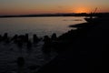 Sunset with a clear sky and sunlight reflexing on the surface of an ocean in the evening at the beach at the sea in fishing town i