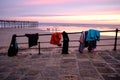 Sunset with clothing hung up on a metal fence with a scenic beach landscape in the background