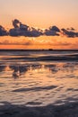 Sunset on a cloudy colorful sky over the North Sea in Denmark with high reflection in the water, vertical Royalty Free Stock Photo