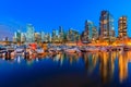 Sunset at Coal Harbour in Vancouver British Columbia with downtown buildings boats and reflections in the water Royalty Free Stock Photo