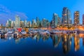 Sunset at Coal Harbour in Vancouver British Columbia with downtown buildings boats and reflections in the water Royalty Free Stock Photo