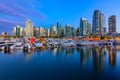 Sunset at Coal Harbour in Vancouver British Columbia with downtown buildings boats and reflections in the water Royalty Free Stock Photo