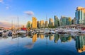 Sunset at Coal Harbour in Vancouver British Columbia with downtown buildings boats and reflections in the water Royalty Free Stock Photo