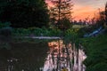 Sunset color reflection in the pond`s friable water