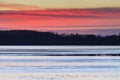 Sunset colored sky and lake with ice