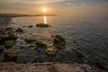 Golden hour sunset at Colwyn bay, North Wales. Warm sky and gentle waves along a rocky coastline Royalty Free Stock Photo