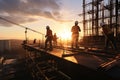 At sunset, construction site silhouettes include crane and diligent workers Royalty Free Stock Photo