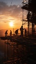 At sunset, construction site silhouettes include crane and diligent workers Royalty Free Stock Photo