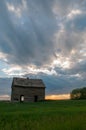 Sunset and a couple abandoned and broken down farm house in the Alberta prairies