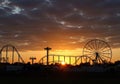 Amusement Park Silhouette at Sunset with Ferris Wheel and Roller Coaster Royalty Free Stock Photo