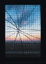 Sunset through cracked glass of an anti-vandal reinforced industrial window Royalty Free Stock Photo