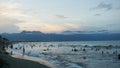 Sunset in a crowded beach with small waves