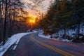 Driving down a wintry road into the sunset Royalty Free Stock Photo