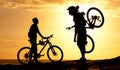 Sunset cyclists. Silhouette of a couple with their bicycles on the beach. Royalty Free Stock Photo