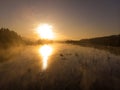 Sunset or dawn on a morning lake or swamp, steam and haze Royalty Free Stock Photo