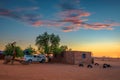 Sunset at a desert camp in Namibia with a pickup 4x4 car with a roof tent