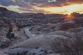 deserted ancient city of Petra in Jordan. The sun sets behind the mountains illuminating the tomb