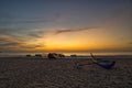 sunset over the sea, old boats, cows on the beach, waves and cloudy sky Royalty Free Stock Photo