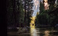 Sunset in distance over dark wooded river in yosemite national park Royalty Free Stock Photo