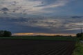 Sunset with a dramatic sky over the agricultural fields in Vroenhoven Royalty Free Stock Photo