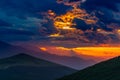 Sunset dramatic sky over mountains landscape in Marche region, Italy. Scenic sunlight beyond storm clouds, distant mountain Royalty Free Stock Photo