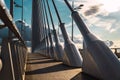 Sunset dramatically over the steel cables of a sidewalk on an urban bridge in Valencia