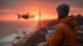 Sunset Drone Flight Over Ocean Cliff with Pilot Using Tablet Royalty Free Stock Photo