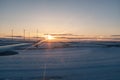 Sunset dusk shining on a snowy landing airport track seen from an airplane window