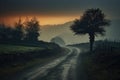 Sunset in the English countryside with a misty road and trees, An early morning elevated shot of a dirt road winding through Royalty Free Stock Photo