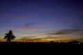 Beautiful light of Sunset with clouds in the sky reflection behind the building and trees Royalty Free Stock Photo