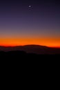 Sunset or evening time over the mountain with small half moon. Royalty Free Stock Photo
