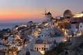 Sunset at famous windmills at beautiful Oia village , Santorini