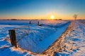 Sunset and fence with grassland in winter Royalty Free Stock Photo