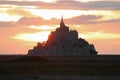 sunset with fiery sky with red clouds and the silhouette of the ancient abbey of Mount Saint Michel in France Royalty Free Stock Photo