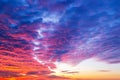 Sunset fire in the sky. Dark blue clouds with red reflections of the setting sun. Scenic sundown cloudscape for background. Royalty Free Stock Photo