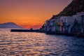 Sunset in fishermen village of Klima, Milos island, Greece. Pair of adults enjoy sunset view on pier of small Royalty Free Stock Photo