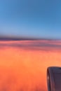 Sunset Flight. Airplane overflying spectacular red clouds