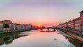 Sunset in Florence over Arno river and lonely kayaker going down by river.