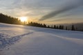 Sunset and footprints on a snow field in a mountain forest Royalty Free Stock Photo