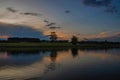 Sunset with forests by the river, with reflection in the water Royalty Free Stock Photo