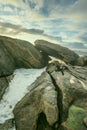 Sunset on the Galician coast of the lower estuaries next to large breakwaters of granodiorite rocks one afternoon with clouds and Royalty Free Stock Photo